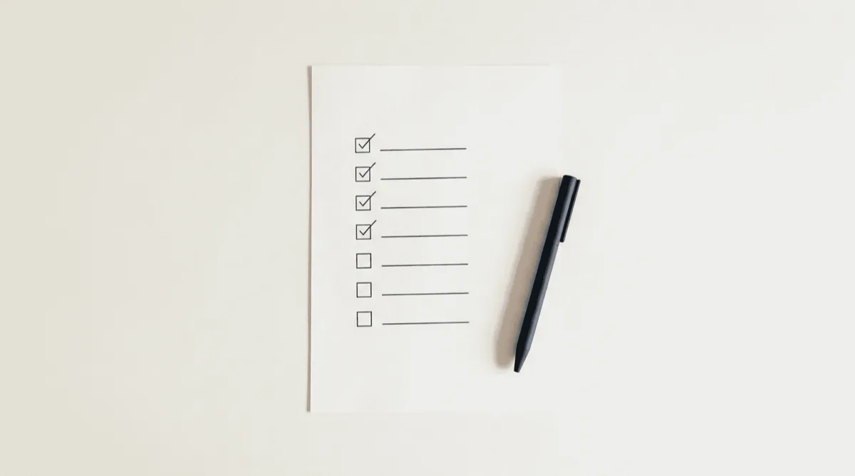 Clean checklist on white desk with pen — structured evaluation criteria for choosing AI customer service
